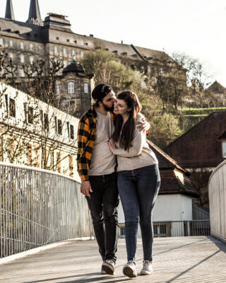 Paar läuft Arm in Arm über Bamberger Brücke.