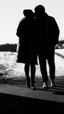 Pärchen im Winter laufen unter einer Brücke.